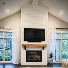 a living room with a fireplace and tv mounted on it's wall above a fire place