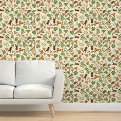 a white couch sitting in front of a wallpapered with giraffes