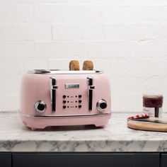 a pink toaster sitting on top of a counter