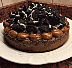 an oreo cookie cake on a plate with chocolate frosting and cookies around it