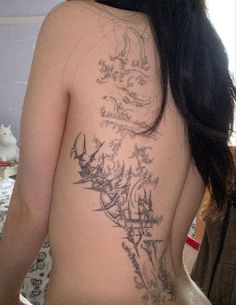 the back of a woman's body with tattoos on it