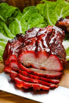 sliced meat on a cutting board with lettuce