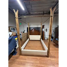 a bed frame made out of wood and white fabric with no headboard or foot board