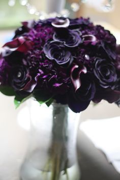 a vase filled with purple flowers on top of a table