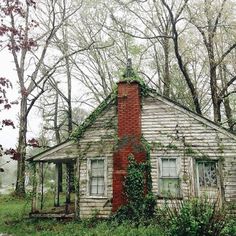 an old run down house with ivy growing on it's roof and window frames