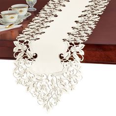 the table runner is made out of paper and has an intricate lace design on it