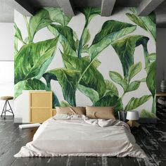 a bedroom with large green leaves painted on the wall and bed in front of it