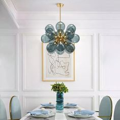 a dining room table with plates and place settings in front of a painting on the wall