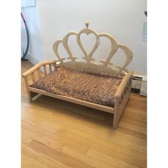 a wooden bed with a crown shaped headboard and foot board on top of it