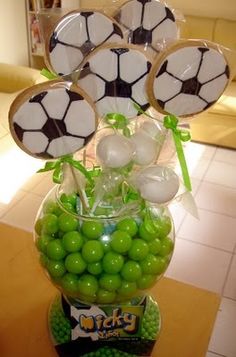 a vase filled with green candies and soccer balls