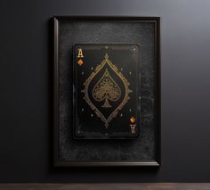 an ace playing card in a frame on a wall