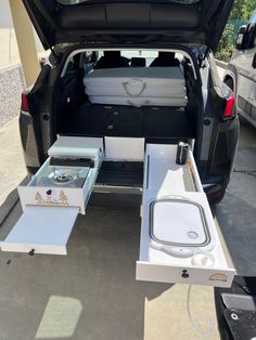 the back end of a car with an open trunk and two white boxes in it