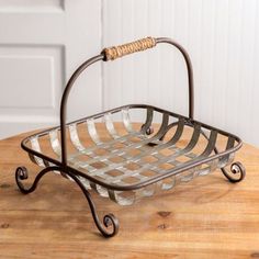 a metal basket sitting on top of a wooden table