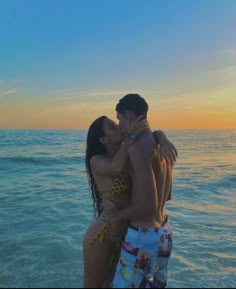 a man and woman kissing on the beach