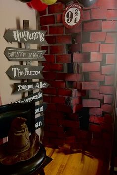 there are many balloons and signs on the wall in front of this brick wall that says hogwart's