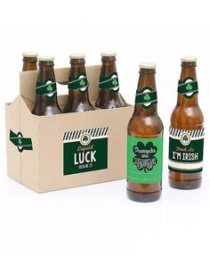 six bottles of beer sitting next to each other in front of a cardboard box on a white surface