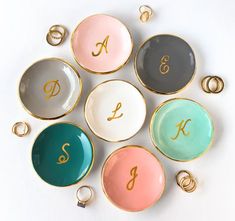 six different colored plates with gold letters and numbers on them, arranged in a circle