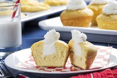 two cupcakes with white frosting are on a plate