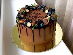 a cake with chocolate icing and berries on top