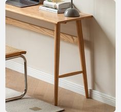 a laptop computer sitting on top of a wooden desk next to a chair and table