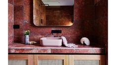 a bathroom sink sitting under a large mirror next to a wooden cabinet and counter top