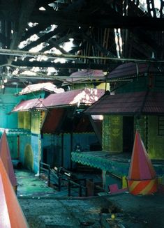 the inside of an abandoned building with colorful umbrellas