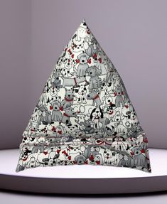 a triangle shaped object with various animals on it's sides and the top half covered in black and white fabric