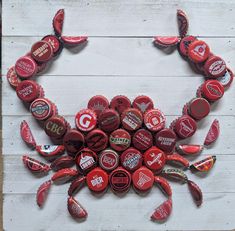 a crab made out of bottle caps on top of a wooden table with white boards