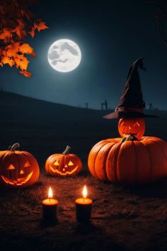 three pumpkins sitting on the ground with candles in front of them and a full moon behind them