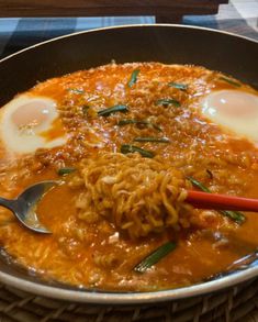 a bowl filled with noodles and eggs on top of a table