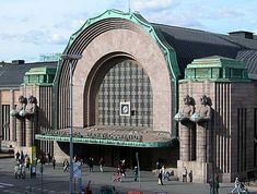 a large building with many statues on it's sides and people walking around outside