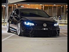 a black car parked in a parking lot at night