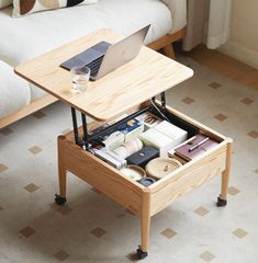 a laptop computer sitting on top of a wooden table in a living room next to a couch