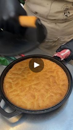 a pan with some food inside of it on a table next to other cooking utensils