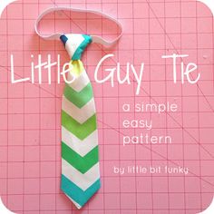 a green and white striped tie hanging on a pink background with the words little guy tie