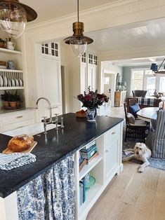 a kitchen with a black counter top next to a dining room table and two chairs