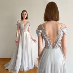 the back of a woman's dress is shown in front of a white wall