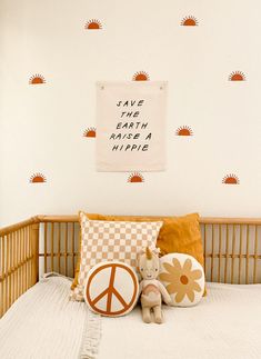 there is a peace sign on the wall above the bed and two stuffed animals in front of it