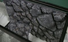 a large pile of rocks sitting on top of a table next to a mirror and plastic bag