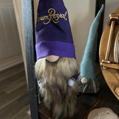 a stuffed animal with a purple hat on top of it's head next to a clock