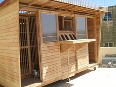 a small wooden building with bars on the outside and windows in the top floor area