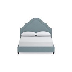 an upholstered bed with white pillows and blue headboard