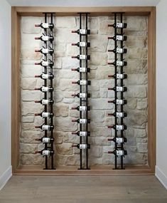 a wine rack in the corner of a room with wooden floors and white brick walls