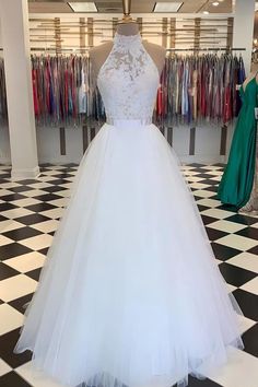 a white wedding dress on display in a store with black and white checkered flooring