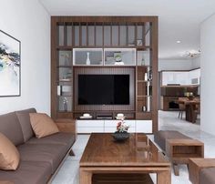 a living room filled with furniture and a flat screen tv mounted on a wall above a wooden coffee table