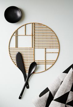 black and white kitchen utensils are on the wall next to a bamboo rack