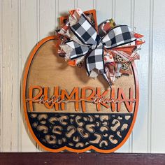 a pumpkin with the words pumpkinkin on it and a bow hanging from it's side