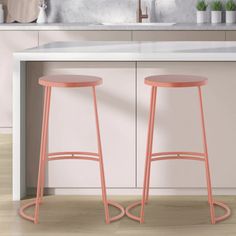 two pink stools sitting in front of a kitchen counter