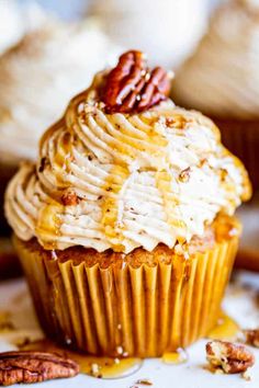 a cupcake with frosting and pecans on top