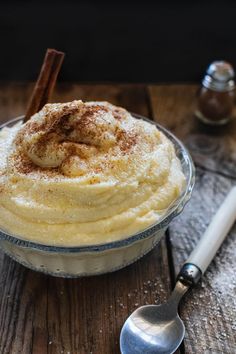 a bowl filled with mashed potatoes on top of a wooden table